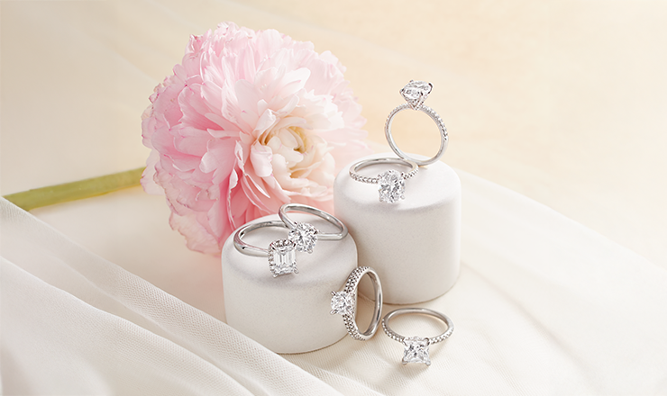 Flat lay of engagement ring alternatives including sapphire and morganite